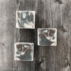 Brown, white and black swirled men's soap sitting on weathered wood tabletop.